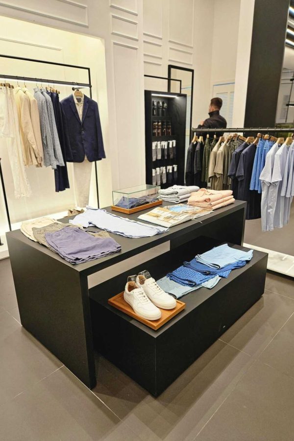 Contemporary clothing store showcasing tailored suits, casual shirts, and accessories.